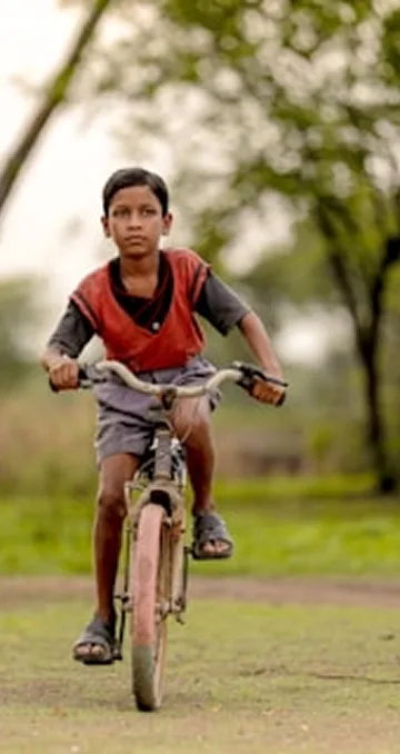A young girl riding a bicycle — representing freedom through education